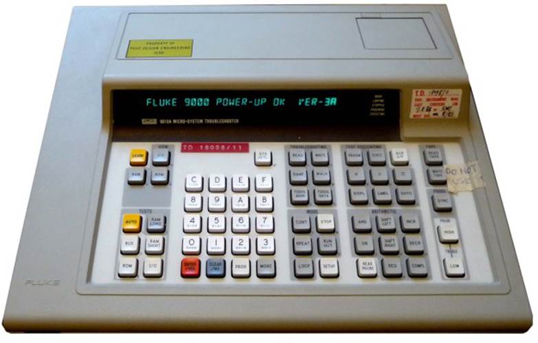 The Fluke 9010A Microsystem Troubleshooter, a desktop test instrument with an array of operating keys, a single-line Vacuum Flourescent display, and microcassette tape storage