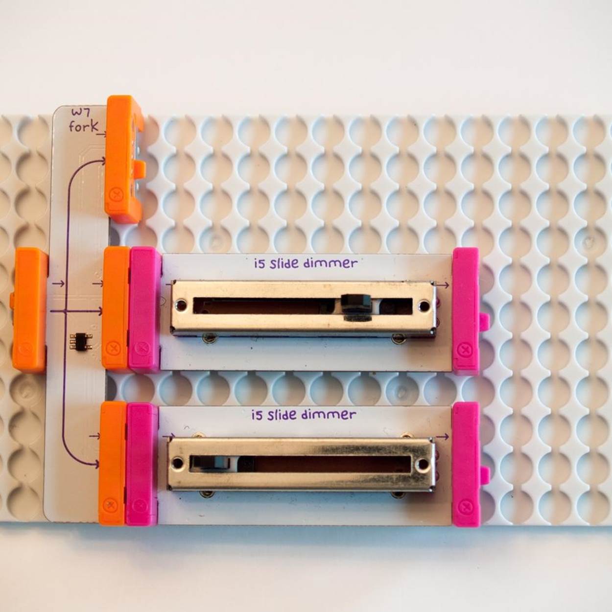 A littleBits Fork and two Slide Dimmers on a Mounting Board