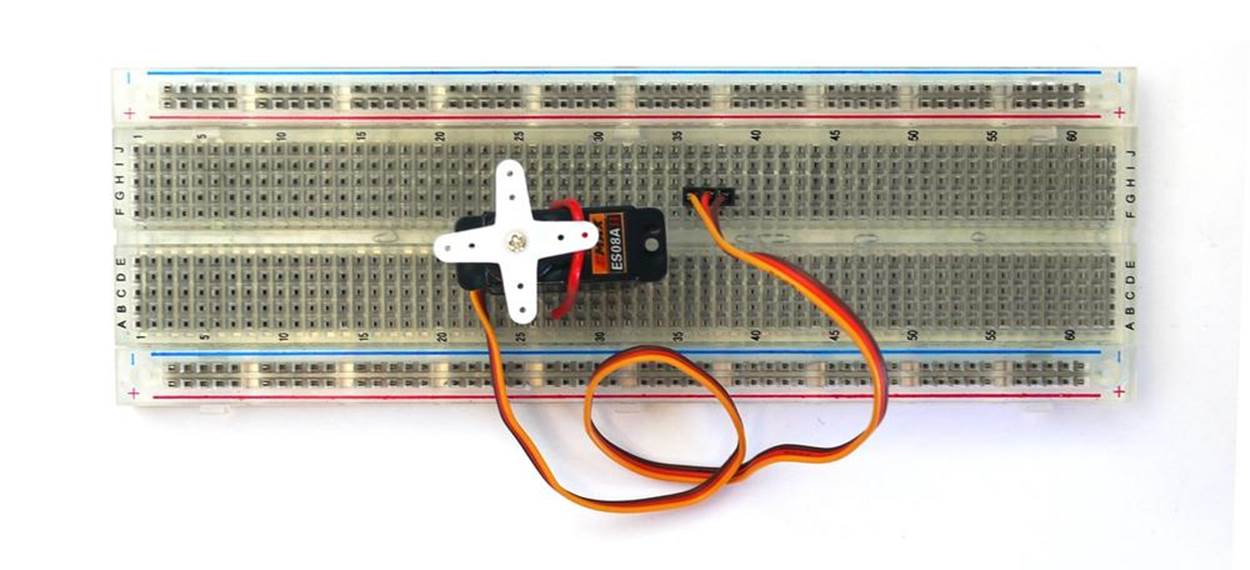 Placing and securing the servo motor on the full-size clear breadboard