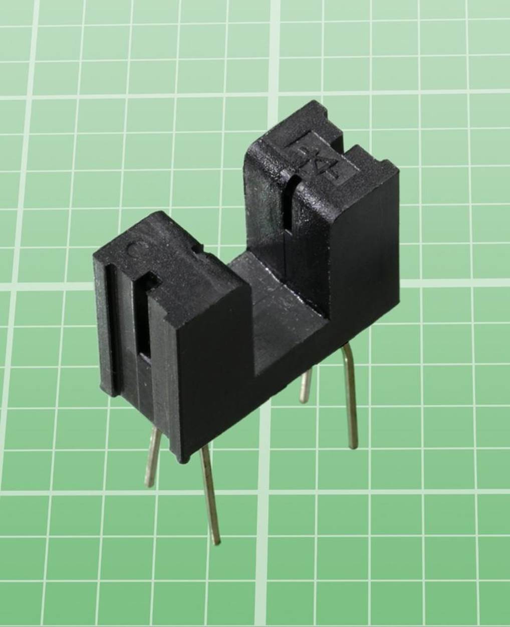 In this Everlight ITR9606-F transmissive sensor, light is transmitted across the gap to a phototransistor facing it in the other half of the component. The schematic symbol for a diode is just visible, molded into the righthand section of the plastic. An infrared LED is mounted in this part.