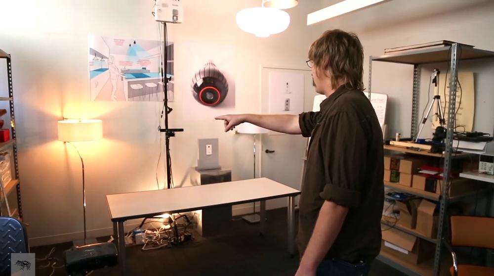 Jared Ficklin demonstrating Room-E; a gesture (pointing at a lamp) is combined with voice input (“Computer, turn off this light”) to control the room (image: Frog Design / Taylor Hamilton)